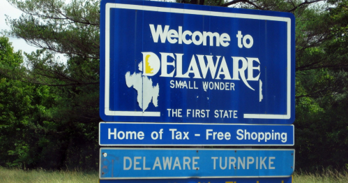 Welcome sign for Delaware, featuring "Small Wonder" and "Home of Tax-Free Shopping," with the Delaware Turnpike below.
