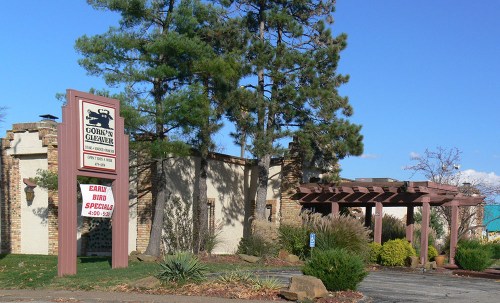 Exterior view of Gordon's Glebe restaurant, featuring a sign and a covered entrance surrounded by greenery.