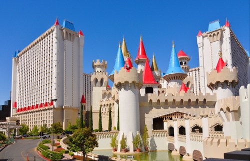 A colorful castle-themed hotel with turrets and a blue sky in the background.