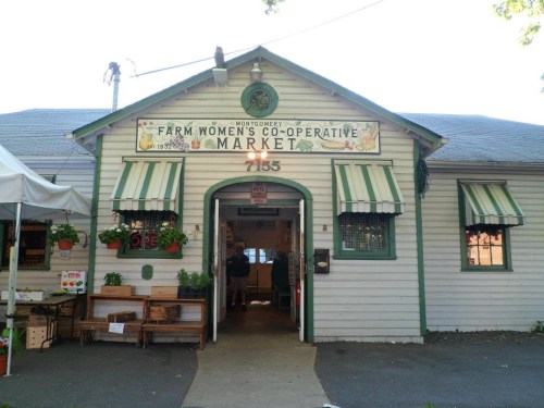 Exterior of the Montgomery Farm Women's Co-operative Market, featuring a welcoming entrance and green-striped awnings.