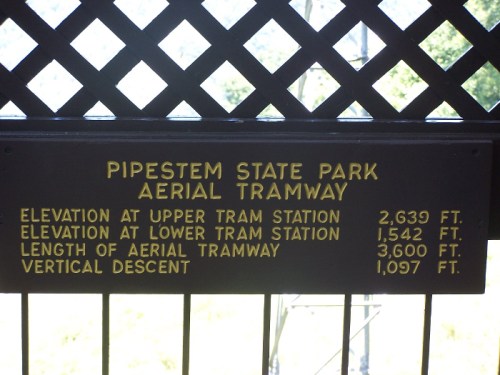 Sign at Pipestem State Park detailing aerial tramway statistics: elevations, length, and vertical descent.