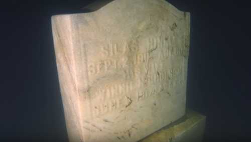 Close-up of an old, weathered gravestone with inscriptions partially visible, set against a dark background.