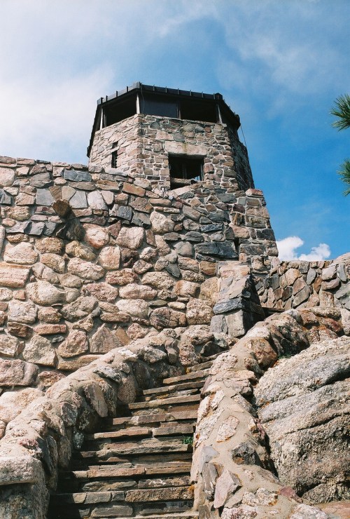Stone staircase leading up to a tall watchtower against a blue sky.