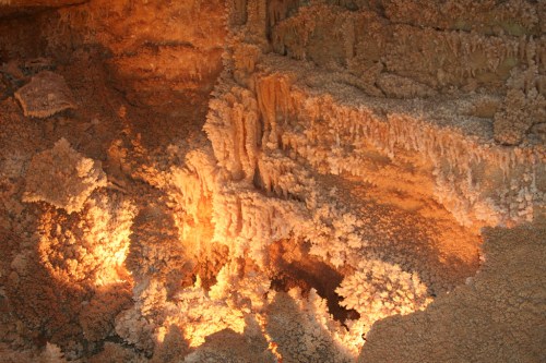 Glowing mineral formations in a cave, showcasing intricate textures and warm lighting.