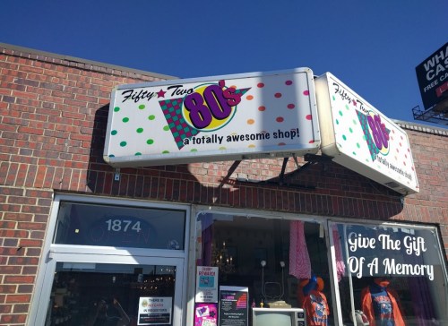 Sign for "Fifty Two 80's," a colorful shop with a retro theme, featuring polka dots and a playful slogan.