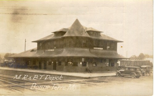Historic train depot in Bonne Terre, Missouri, featuring a distinctive architectural design and vintage cars nearby.