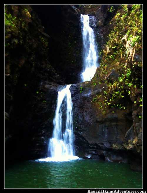 A serene waterfall cascading into a dark pool, surrounded by lush green rock formations.