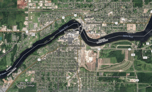 Aerial view of International Falls, Minnesota, featuring the Rainy River and surrounding urban and industrial areas.
