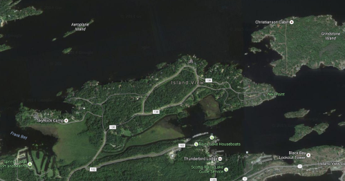 Aerial view of a coastal area featuring islands, waterways, and nearby land with roads and buildings.