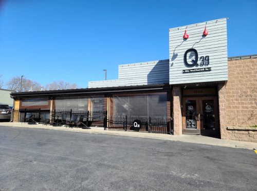 Exterior of Q29 restaurant with a modern design, featuring large windows and a welcoming entrance on a clear day.