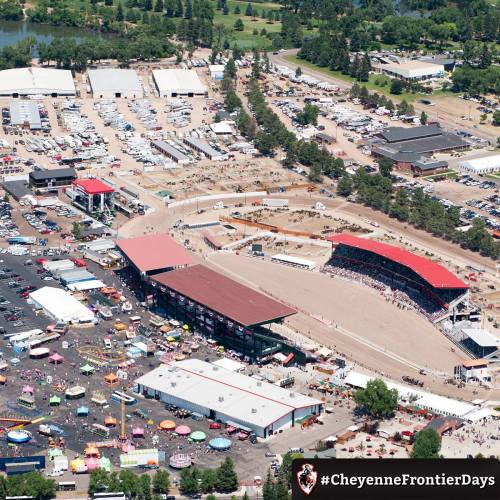 Aerial view of a large outdoor event with a rodeo arena, fairgrounds, and various attractions.
