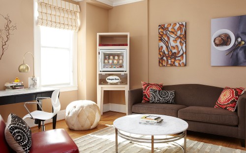 Cozy living room with a brown sofa, decorative pillows, a marble coffee table, and artwork on the walls.