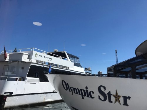 Two boats docked at a marina under a clear blue sky, with one labeled "Waterways" and the other "Olympic Star."