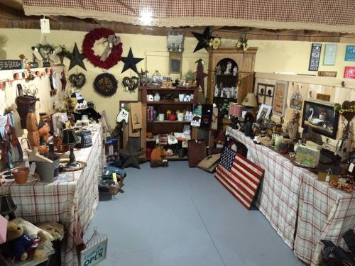 A cozy antique shop filled with various vintage items, decor, and a large American flag on the floor.
