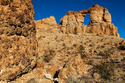 Rocky desert landscape featuring unique rock formations and a clear blue sky.