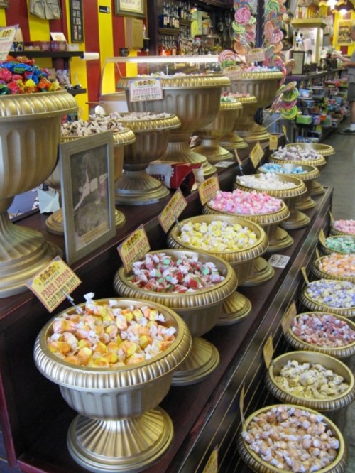 Colorful candy displays in ornate bowls, featuring a variety of sweets in a vibrant shop setting.