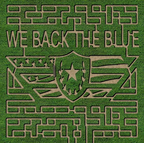 A green maze design featuring the text "We Back the Blue" and a shield with a star and stripes.