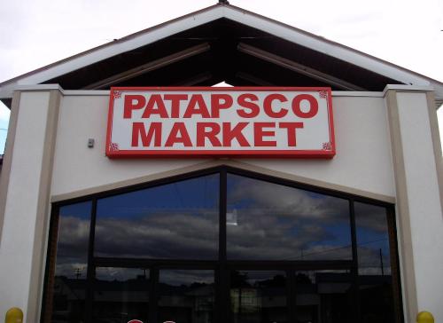 Sign for Patapsco Market displayed prominently on a building with a cloudy sky in the background.