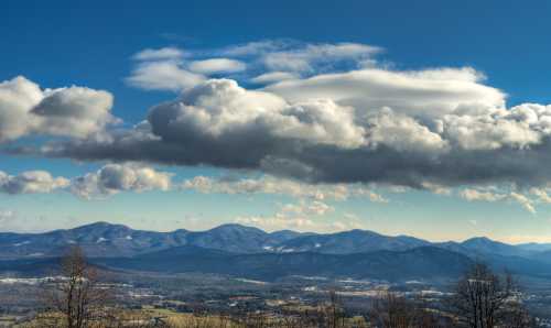 A scenic view of snow-capped mountains under a blue sky with fluffy clouds.