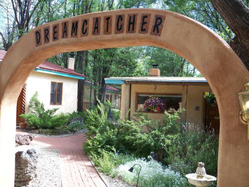 A charming entrance archway labeled "Dreamcatcher" leading to a serene garden and colorful buildings.