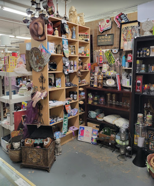 A cozy vintage shop corner filled with shelves of eclectic items, including decor, books, and collectibles.