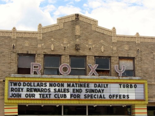 Sign on the Roxy theater building advertising $2 matinees, Turbo, and a text club for special offers.