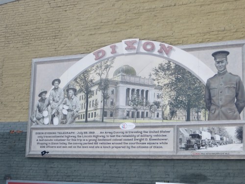 Historic mural depicting early transportation in Dixon, featuring a building, soldiers, and a vintage vehicle scene.