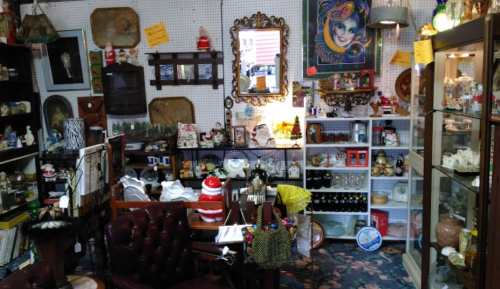 A cozy antique shop filled with various vintage items, including furniture, decor, and collectibles on display.