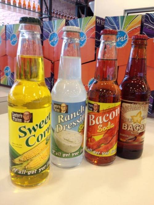Four novelty soda bottles: sweet corn, ranch dressing, bacon, and chocolate bacon flavors, displayed on a counter.