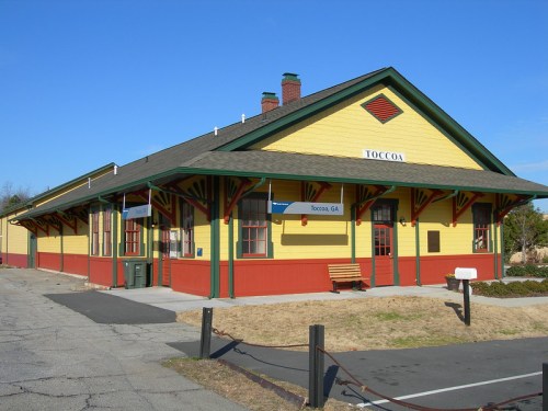Historic yellow and red train station in Toccoa, GA, featuring a gabled roof and decorative trim.