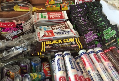 A colorful assortment of candies, including Turkish taffy, Pop Rocks, and Black Cow bars, displayed on a table.