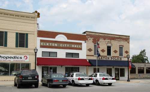 Image of Elkton City Hall and Elkton Police Department, featuring parked police cars and a cloudy sky.