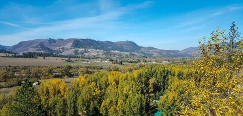 A scenic view of rolling hills and vibrant autumn trees under a clear blue sky.
