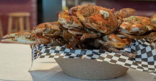 Close up of crabs in a cardboard bowl and black and white checked paper in Maryland