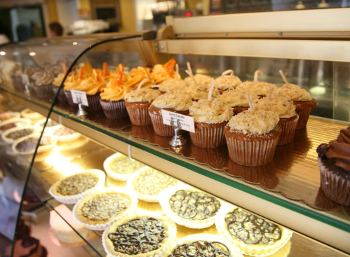 A display case filled with various cupcakes and desserts, showcasing colorful frosting and toppings.