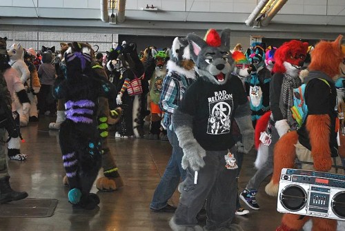 A vibrant gathering of furries in costumes, featuring various animal characters and colorful designs in a convention setting.