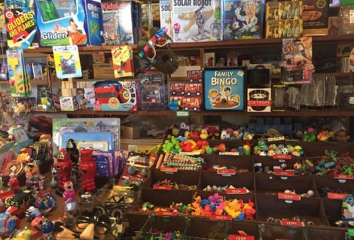 A colorful display of toys and games, including bingo, robots, and various small trinkets in a shop setting.