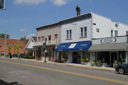 A quaint street scene featuring charming storefronts and a clear blue sky.