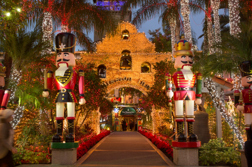 A festive entrance adorned with lights, nutcracker statues, and lush greenery, creating a holiday atmosphere.