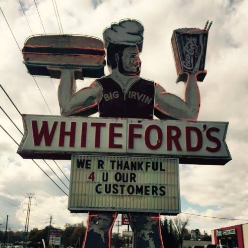 A large retro sign for Whiteford's featuring a chef holding food and a drink, with a message thanking customers.