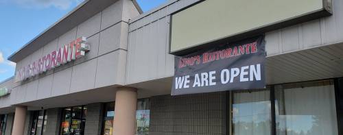 A restaurant storefront with a sign that reads "Lino's Ristorante" and a banner stating "WE ARE OPEN."