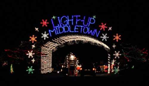 Colorful holiday lights form an archway reading "Light Up Middletown" against a dark night sky.