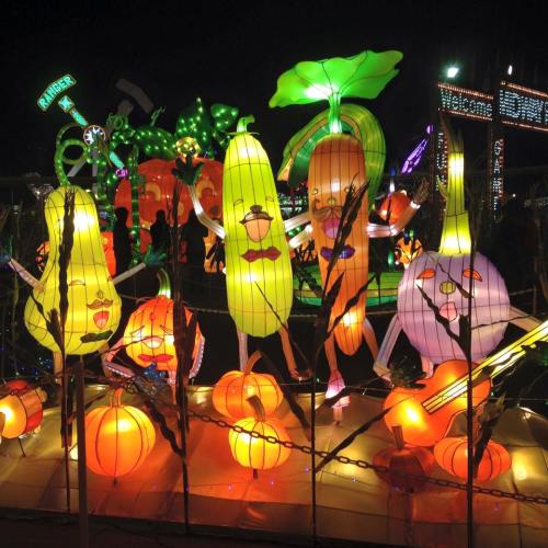 Colorful lanterns shaped like fruits and vegetables, illuminated at night, creating a festive atmosphere.