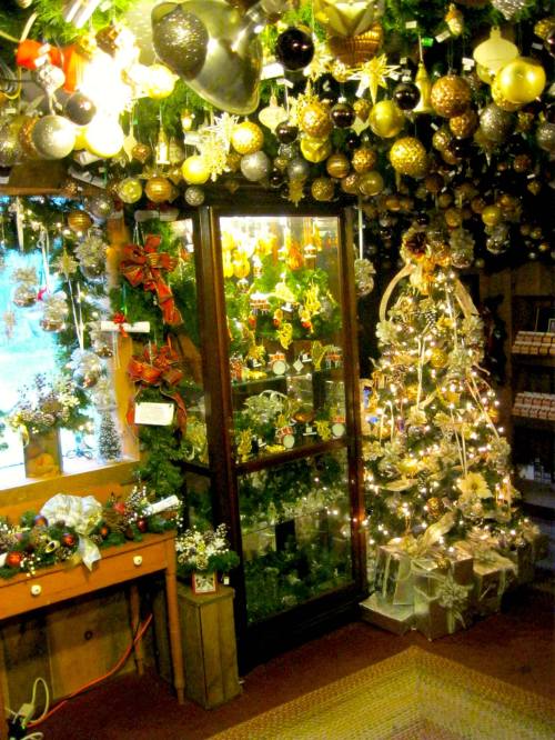 A cozy holiday shop adorned with festive decorations, including a decorated Christmas tree and sparkling ornaments.