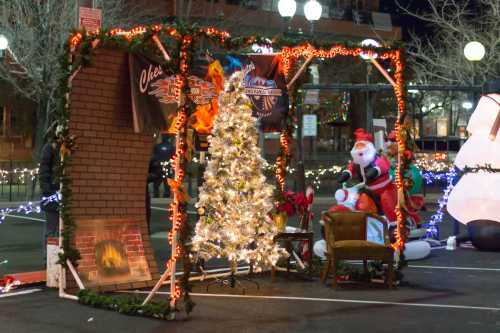 A festive holiday display featuring a decorated Christmas tree, Santa Claus, and a cozy fireplace scene.