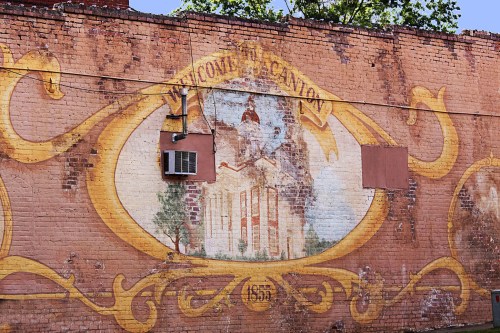 Mural on a brick wall featuring the text "Welcome to Canton" with a faded building illustration.