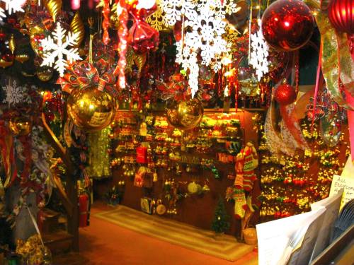 A festive shop filled with colorful Christmas decorations, ornaments, and snowflake ornaments hanging from the ceiling.