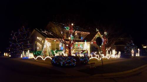 A beautifully decorated house at night, adorned with colorful Christmas lights and festive displays.