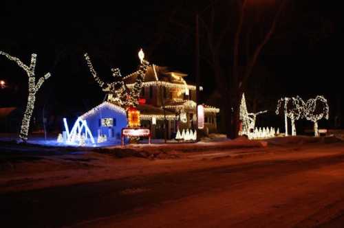 A beautifully decorated house with colorful Christmas lights and festive displays, set against a dark night sky.