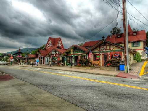 Charming alpine-style buildings line a street under a dramatic, cloudy sky.